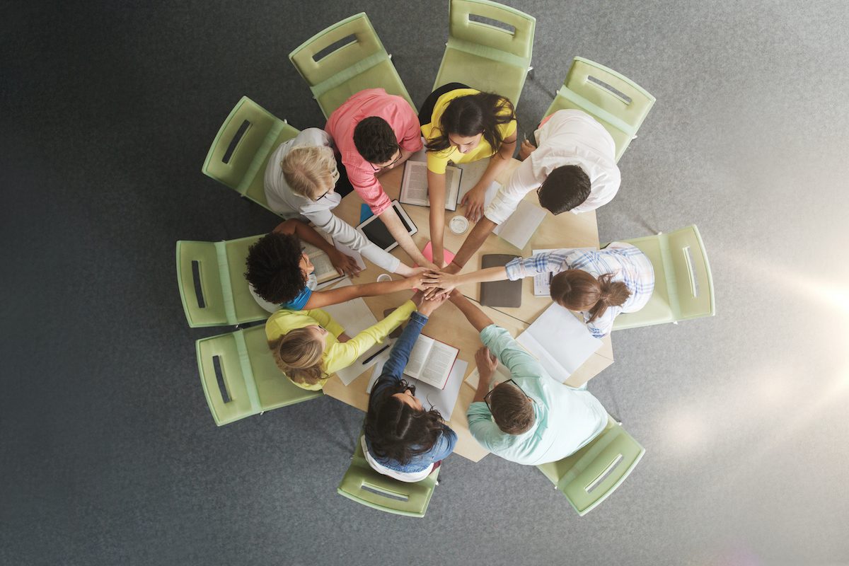 group of international students with hands on top