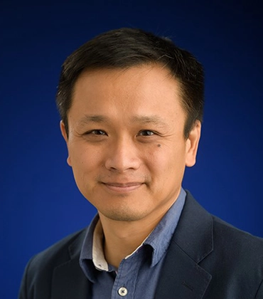 Portrait of Gad Lim on a blue studio background.