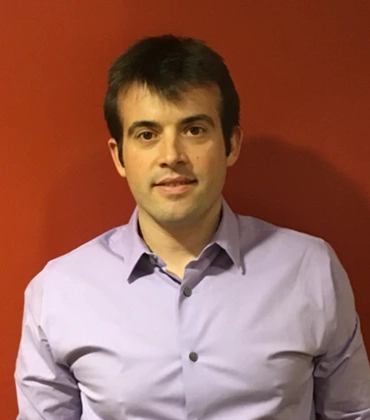 Portrait of Spiros Papageorgiou on an orange background.
