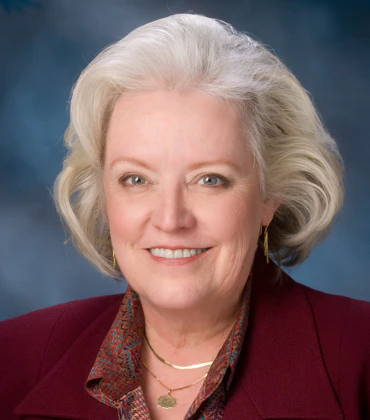 Portrait of Kathleen Bailey on a blue background.